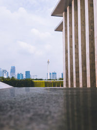 View of buildings in city against cloudy sky