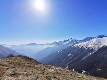 Scenic view of snowcapped mountains against clear blue sky