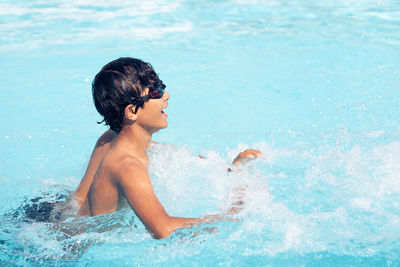 Side view of shirtless boy in swimming pool