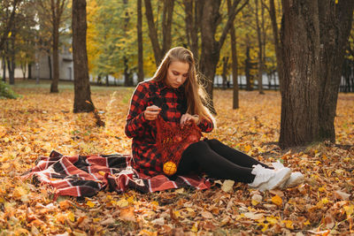 Young woman with autumn leaves in forest