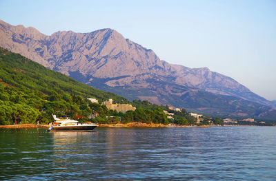 Scenic view of lake and mountains against clear sky