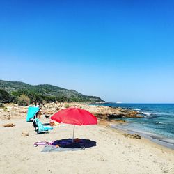 Scenic view of beach against clear blue sky