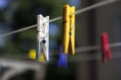 Close-up of clothespin hanging on clothesline outdoors