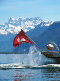 Swiss flag on passenger craft against snowcapped mountain