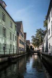Canal amidst buildings in city against sky