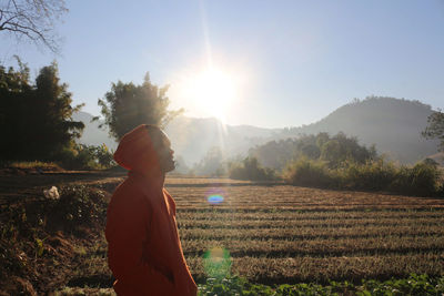 Man standing on field against sky