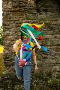 Full length of a woman waving with rainbow ribbons. 