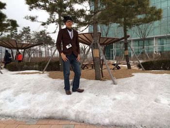 Portrait of man standing on snow at park