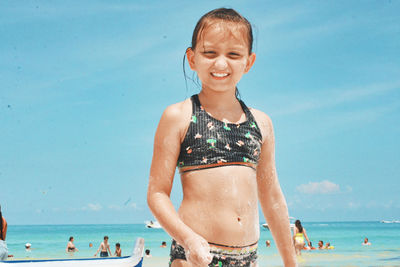 Portrait of smiling woman on beach against sky