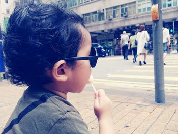 Close-up of cute boy eating lollipop on street