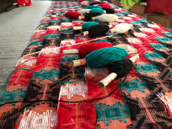 Close-up of multi colored thread spools on textile