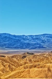 Scenic view of desert against clear blue sky