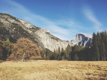 Low angle view of rocky mountains in front of landscape against sky on sunny day