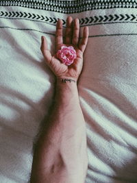 High angle view of woman hand on bed