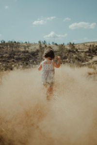 Rear view of girl running on land