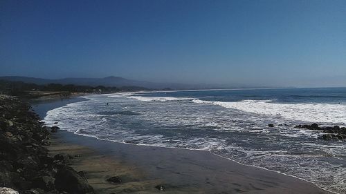 Scenic view of beach against blue sky