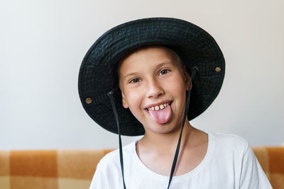 Portrait of charming caucasian boy in white t-shirt and black panama hat