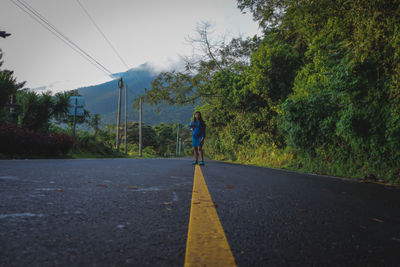 Rear view of a girl walking on road