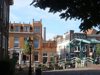 Buildings by street in city against sky