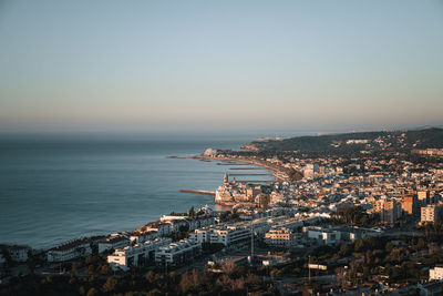 High angle view of townscape by sea against clear sky