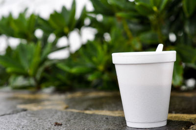 Close-up of drink in glass on retaining wall