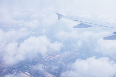 Cropped image of airplane wing over landscape