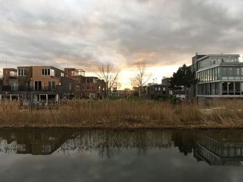 Reflection of buildings on lake against sky