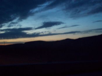 Scenic view of silhouette mountains against sky at sunset