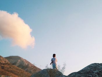 Low angle view of man standing on rock