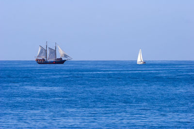 Sailboat sailing on sea against clear sky