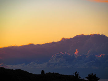 Scenic view of silhouette mountains against orange sky