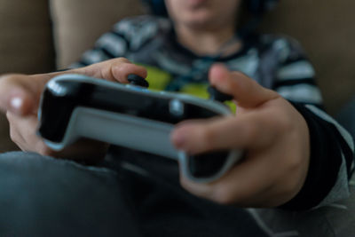 Midsection of boy using mobile phone