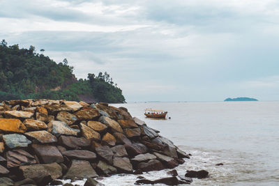 Rocks by sea against sky