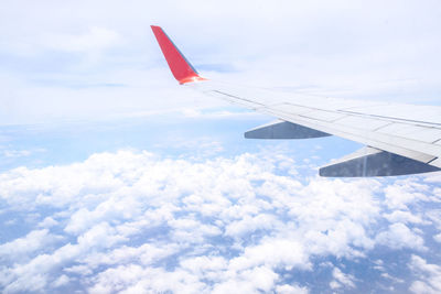 Aerial view of airplane wing over clouds