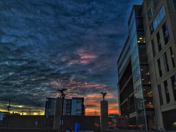 Low angle view of buildings against cloudy sky