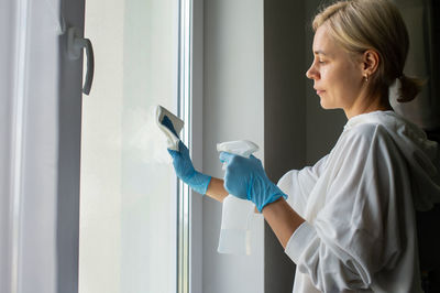 Do house cleaning. girl washes windows with gloves person