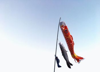 Low angle view of windsocks hanging against sky