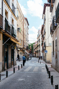 People walking on footpath amidst buildings in city