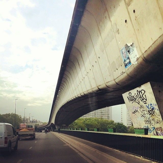 transportation, architecture, built structure, bridge - man made structure, connection, engineering, the way forward, arch, sky, road, bridge, diminishing perspective, car, land vehicle, mode of transport, building exterior, vanishing point, cloud - sky, city, travel