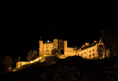 Low angle view of illuminated buildings against sky at night