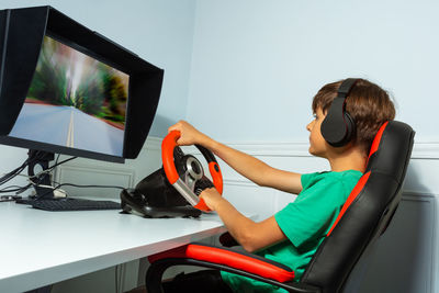 Side view of man using laptop while sitting in car