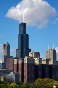 Buildings in city against cloudy sky