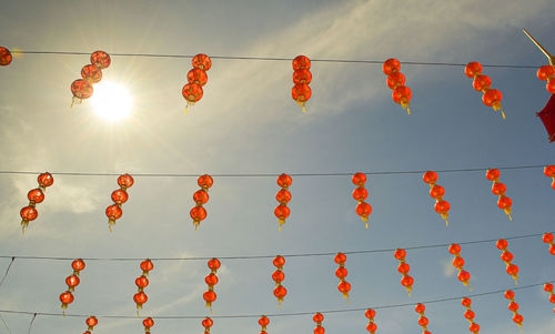 Red lantern decoration with pagoda at back with clear blue sky and sun lights