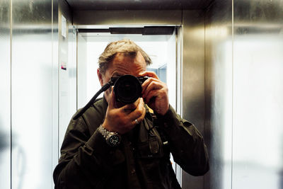 Man photographing in elevator