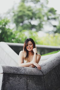 Portrait of smiling woman sitting outdoors