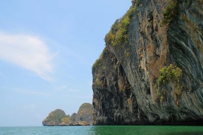 Rock formations by sea against sky