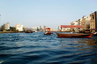 Boats in river with buildings in background