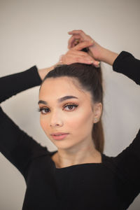 Portrait of young woman with eyes closed against white background