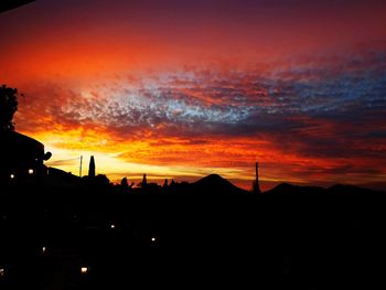 Silhouette buildings against orange sky