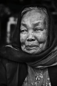 Close-up of senior woman looking away while sitting at home